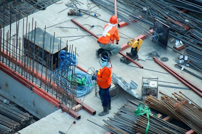 Electrician working on a job site, using Invoiced on their phone